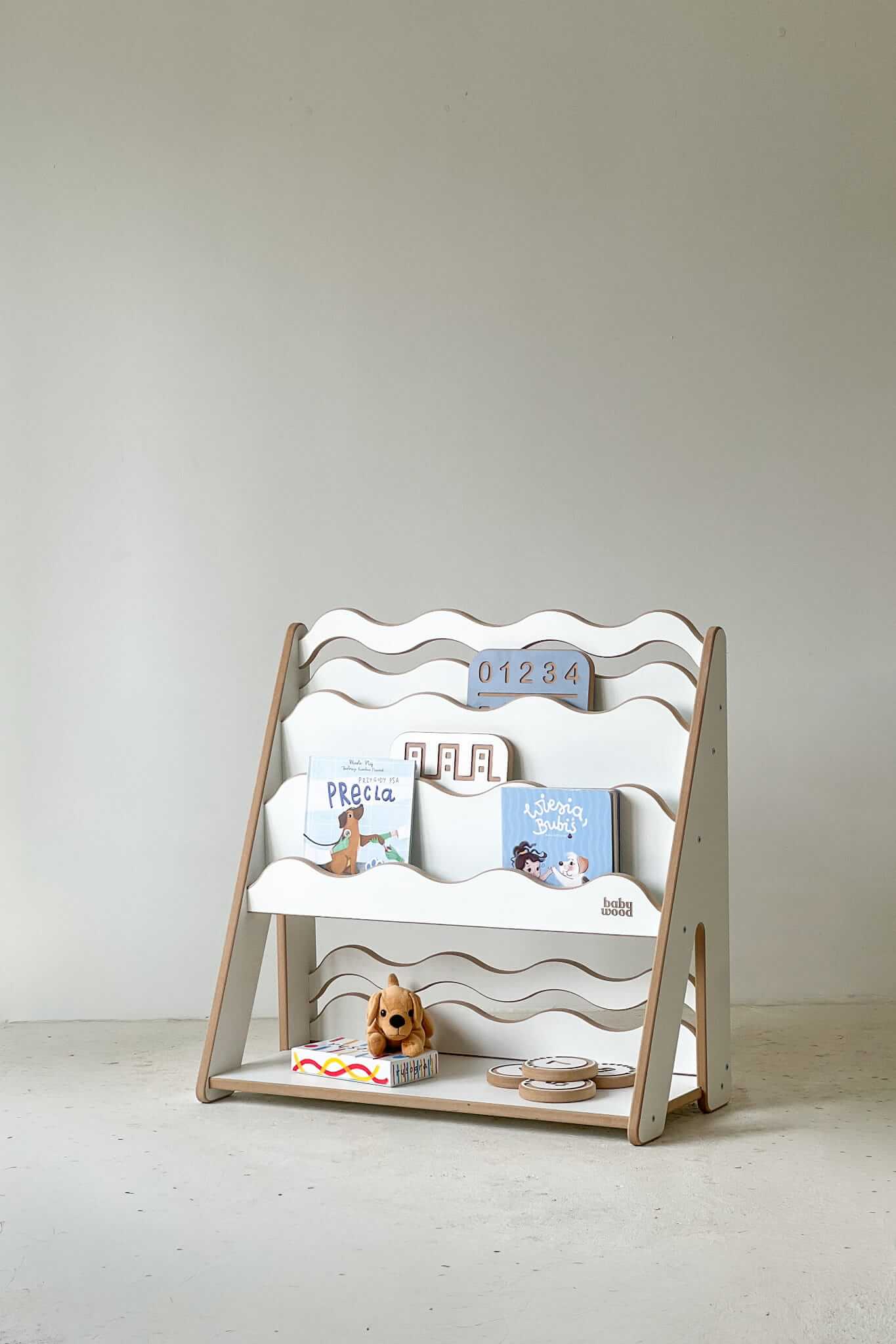 Bücher- und Spielzeugregal "WAVE" aus Holz, versch. Größen mit bunten Kinderbüchern und Spielzeug.