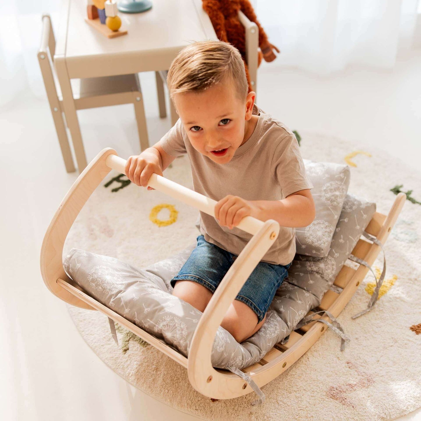 Kind sitzt auf dem Kletterbogen Äffchen und spielt, fördert Bewegungsfähigkeiten und Kreativität.