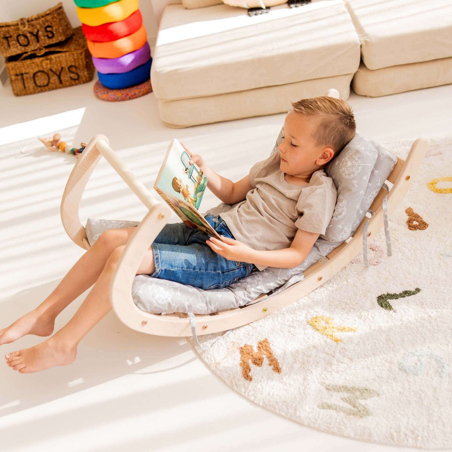 Junge entspannt in einem Kletterstuhl und liest ein Buch, perfekt für Kleinkinder zum Spielen und Entspannen.