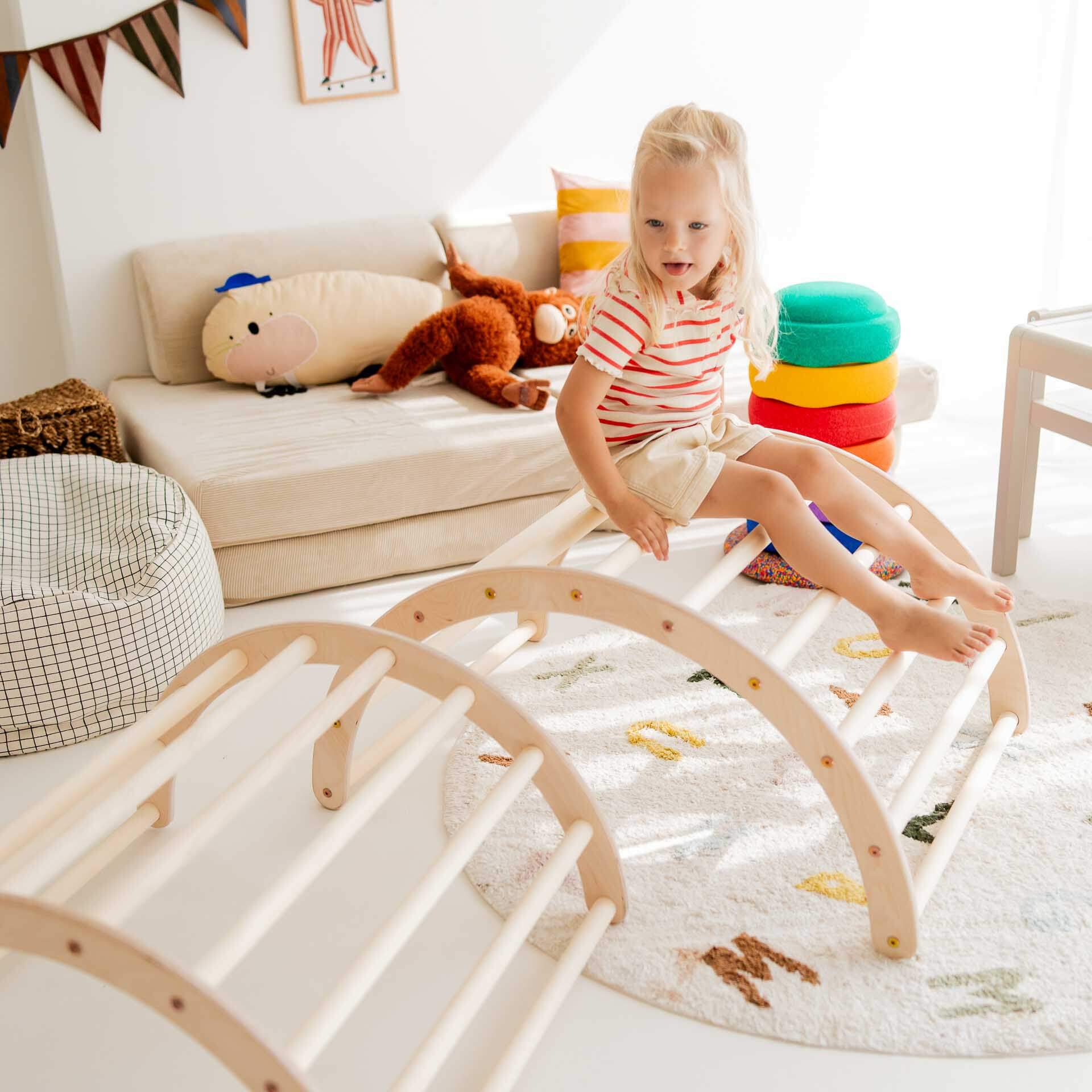 Kind spielt auf Kletterbogen aus Holz, ideal für Bewegung und Spaß, in verschiedenen Größen erhältlich.