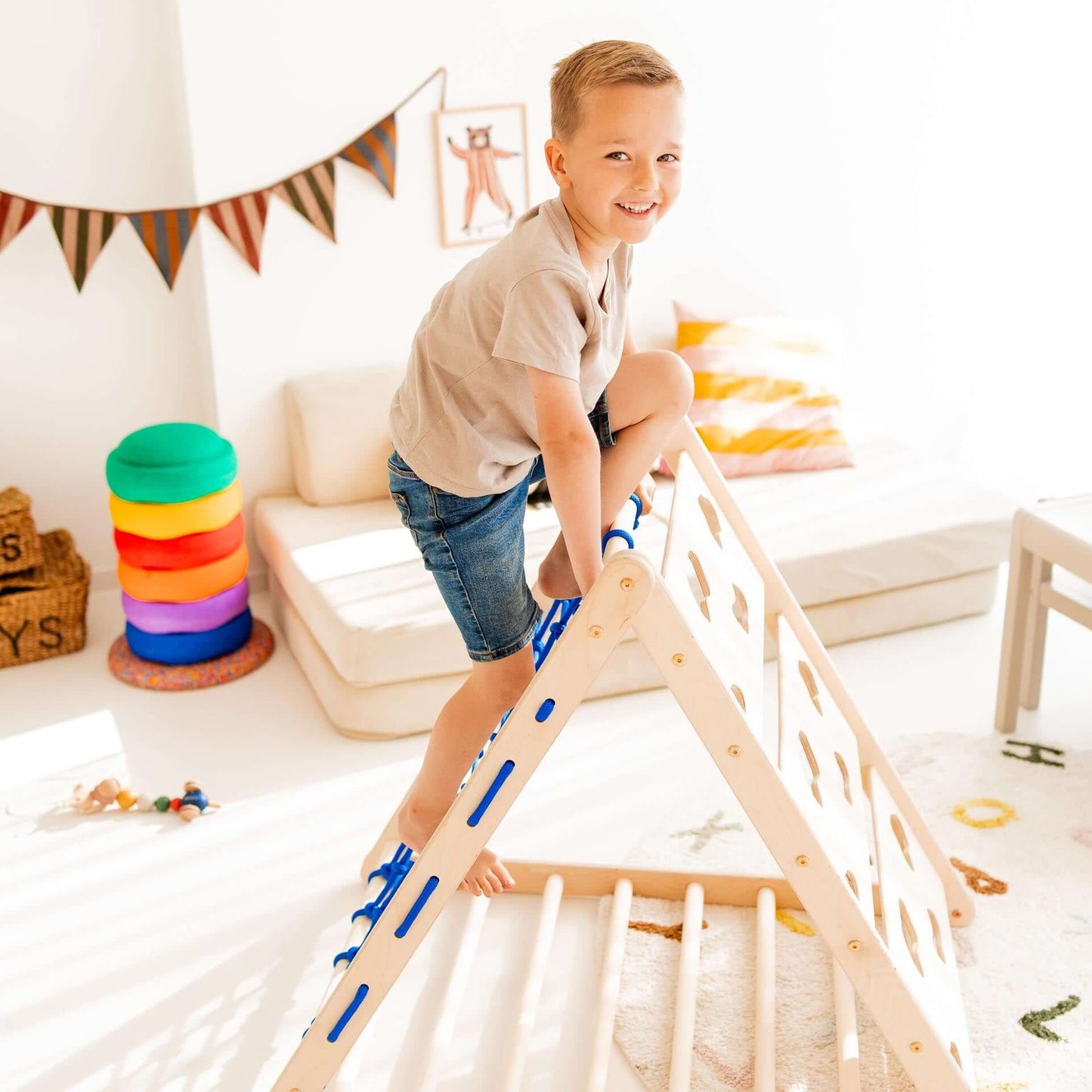 Kletterdreieck Äffchen: glückliches Kind klettert auf dem Spielgerät für Bewegungsförderung und Spaß.