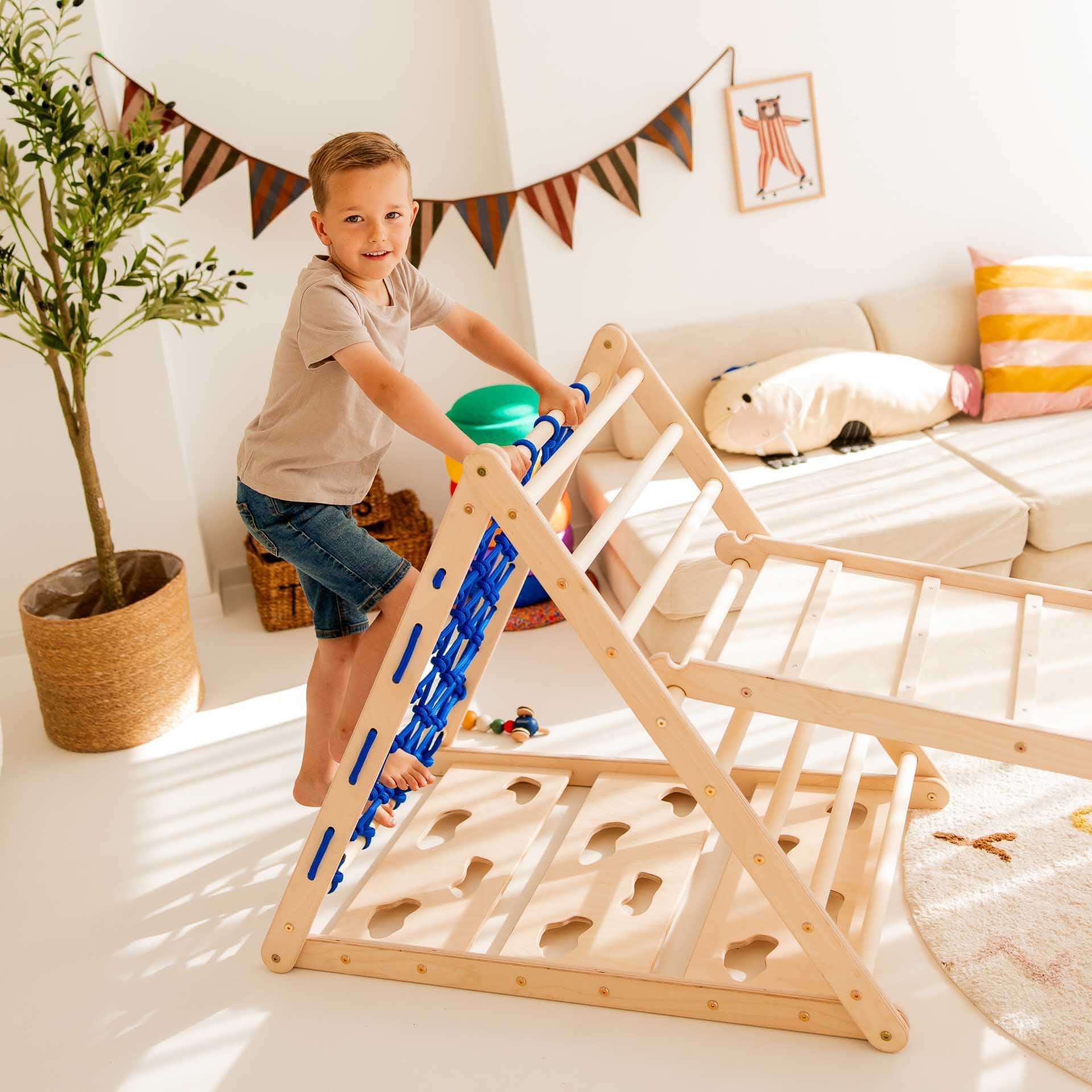 Kind klettert auf dem Kletterset Löwe aus Holz mit Kletterdreieck und Hühnerleiter für spielerische Bewegungsförderung.
