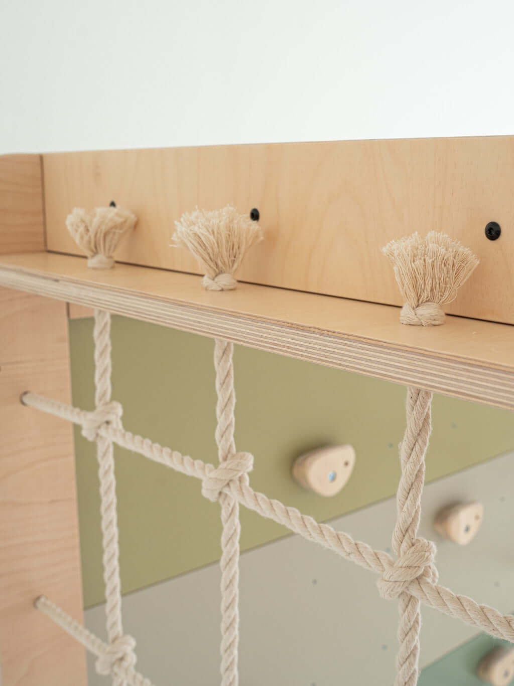 Detailansicht der Kletterwand Klimby "Entdecker" mit Seil und Haltegriffen für kleinen Abenteurer im Indoor Spielplatz.