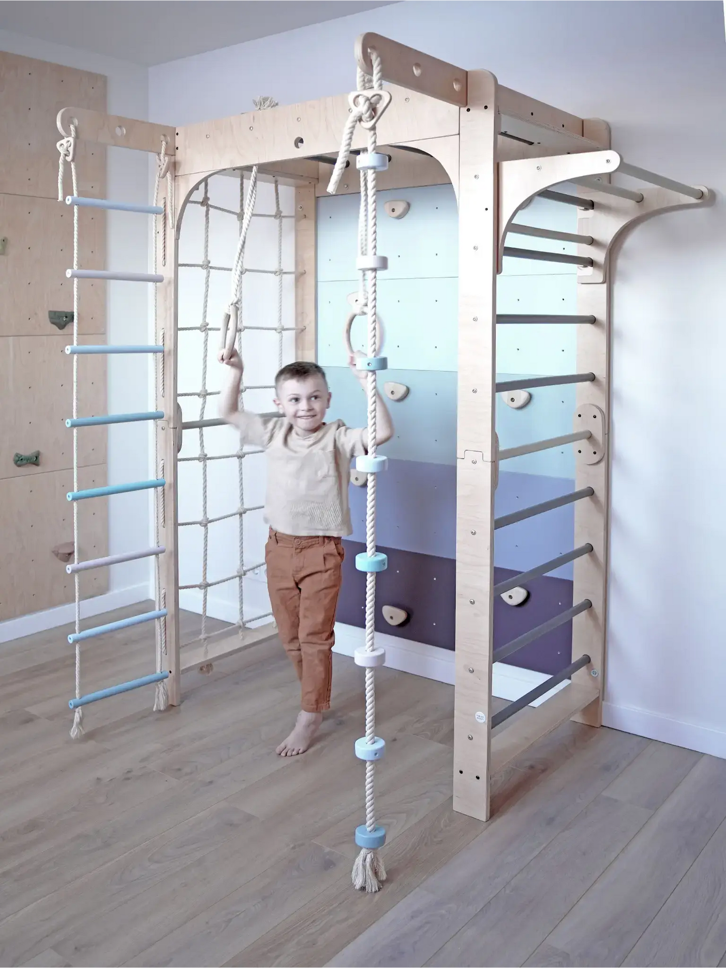 Kletterwand Klimby "Kletterkönig" mit einem Jungen beim Spielen in einem modernen Indoor Spielplatz.