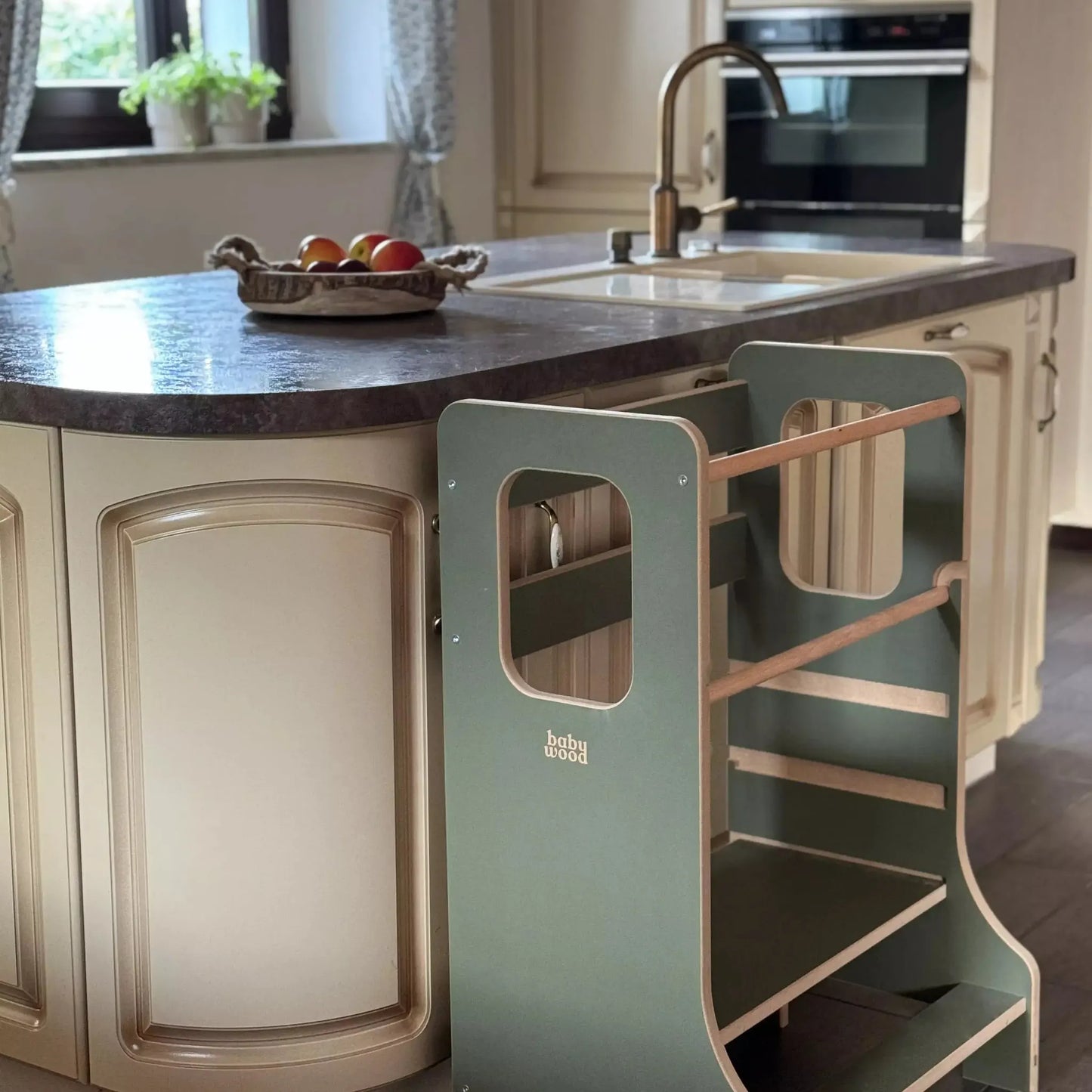 Lernturm TWINS für Geschwister & Zwillinge neben moderner Küche mit Steingrill und Obstschale.