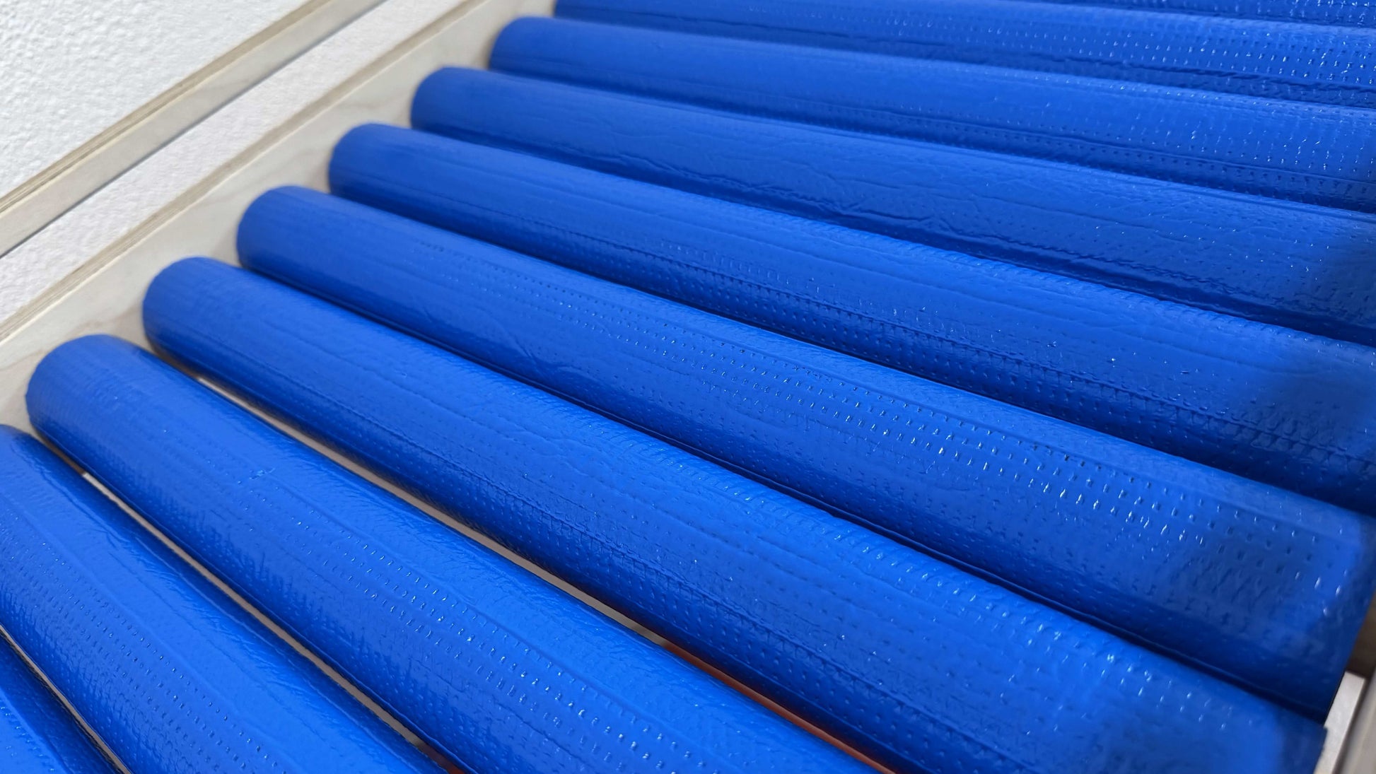 Detailaufnahme der blauen Rollen der Wellen Rollenrutsche für Kinder, ideales Zubehör für die Holzrutsche.