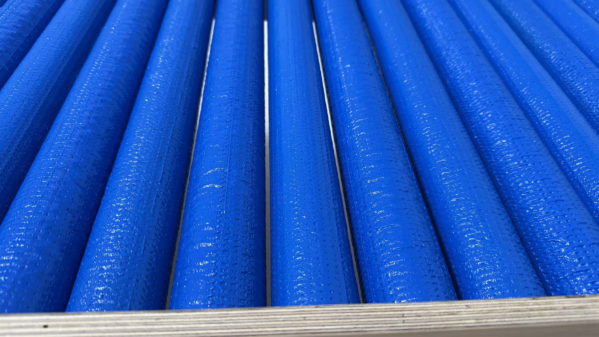 Detailaufnahme der blauen Rollen der Wellen Rollenrutsche für Kinder, die für sicheres Vergnügen beim Rutschen sorgen.