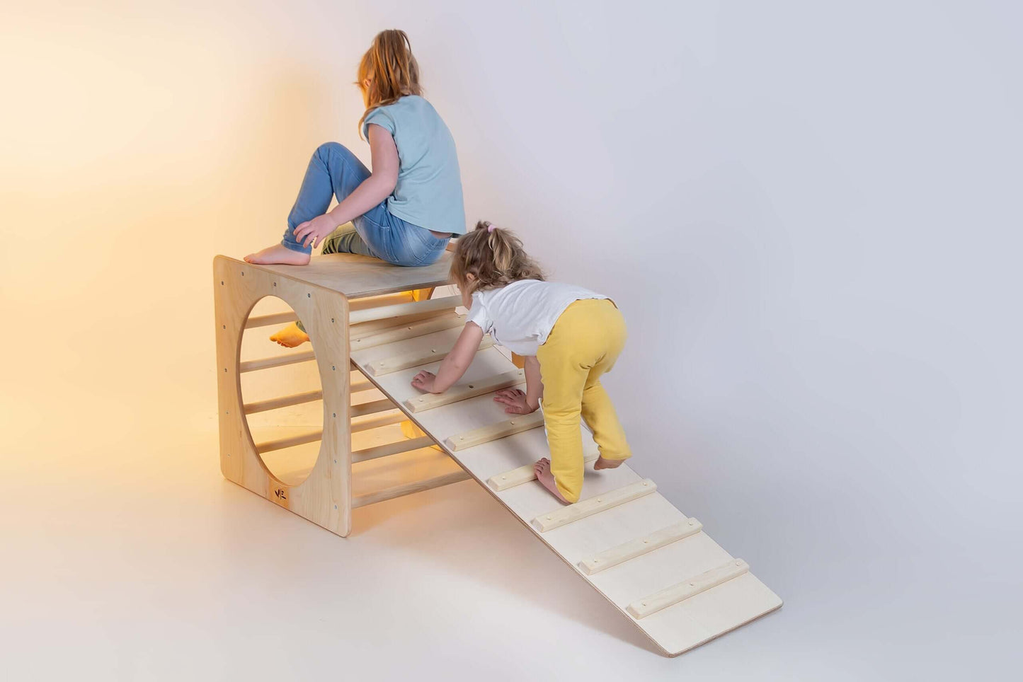 Zwei Kinder spielen auf einem Kletterwürfel versch. Farben aus Holz, entwickeln motorische Fähigkeiten und haben Spaß.