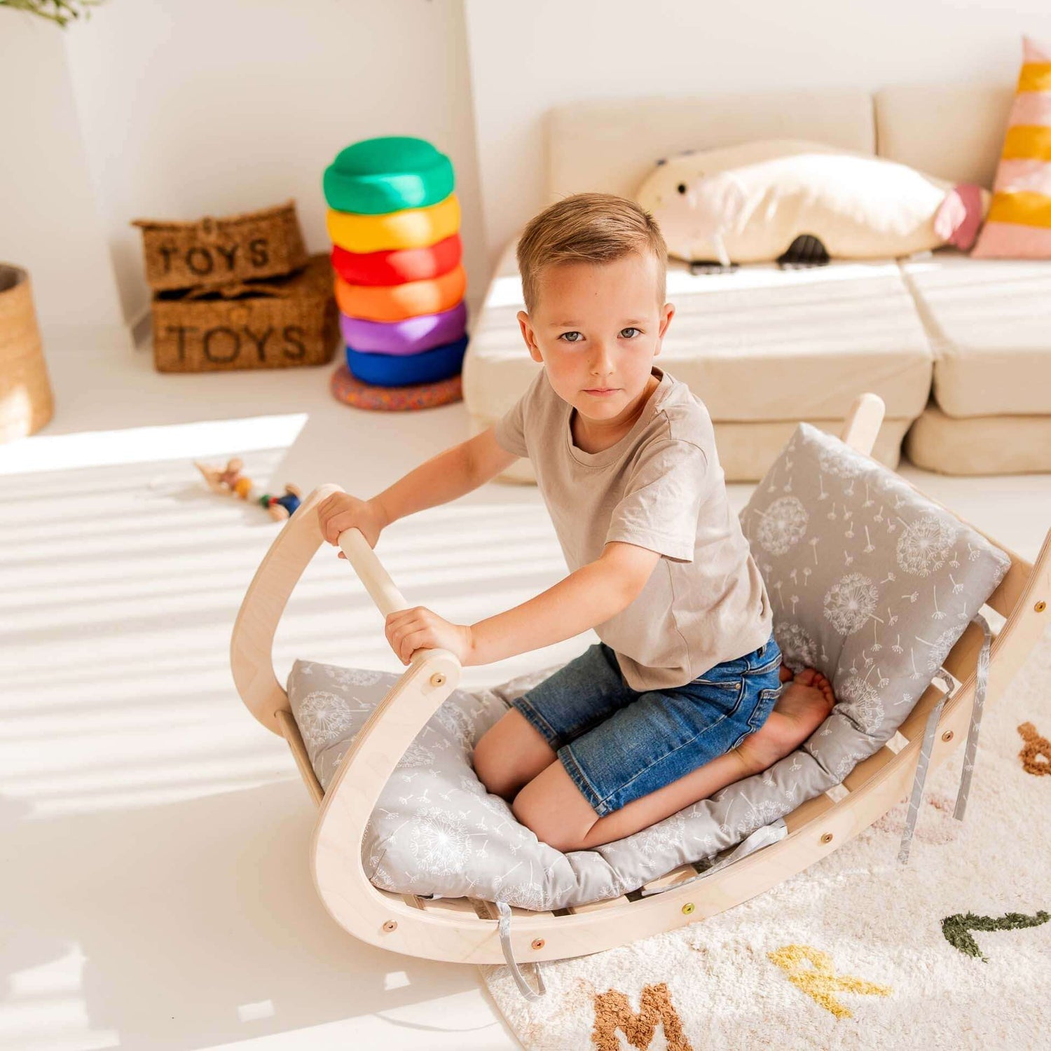 Junge sitzt auf Kletterset Äffchen, einem Holzschaukelgerät mit gepolstertem Sitz, ideal für Spiel und Bewegung.